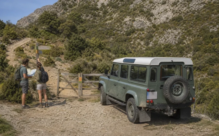 Land Rover Defender 110 detenido ante un acceso de pista para comprobar los permisos